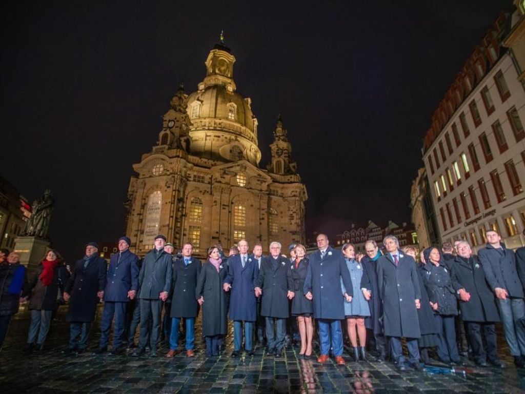 Das Ehepaar Steinmeier bildet gemeinsam mit zahlreichen anderen Teilnehmern eine Menschenkette bei der Gedenkveranstaltung zum 75. Jahrestag der Zerstörung Dresdens. Foto: Jens Büttner/dpa-Zentralbild/dpa