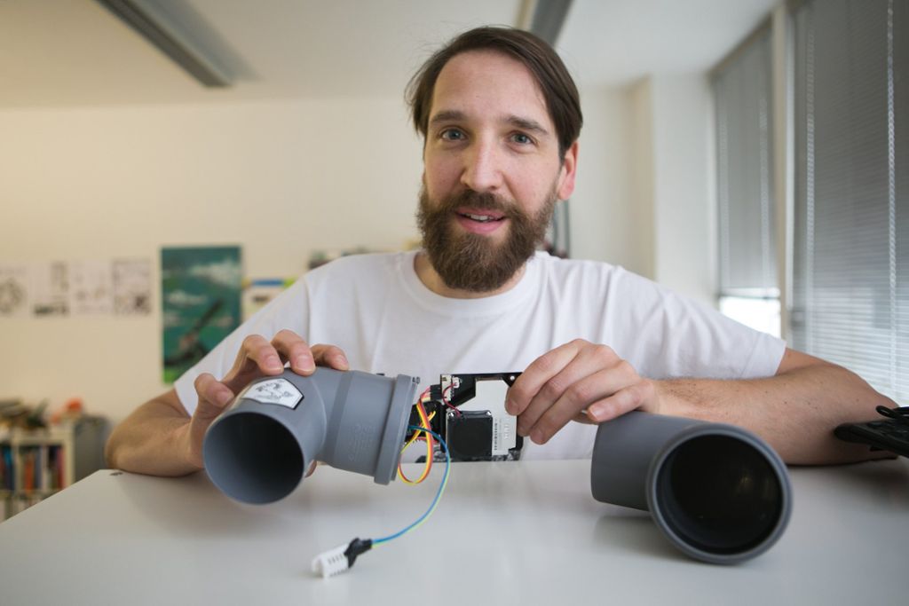 Jan Lutz, Leiter des Ok Lab Stuttgart, präsentiert ein selbst gebautes Feinstaub-Messgerät. Es besteht im Wesentlichen aus einem W-Lan-Chip und einem Sensor, die mit Hilfe von Kabeln verbunden und in Abflussrohren platziert werden. Foto: Bulgrin Quelle: Unbekannt