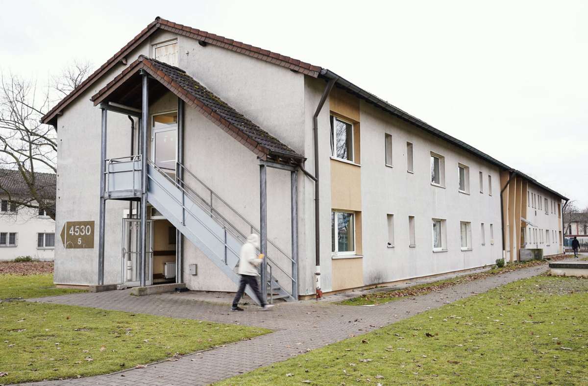 Ein Bewohner geht am 8. 12. 2021 im Ankunftszentrum für Flüchtlinge auf dem Gelände der ehemaligen US-Militärfläche Patrick-Henry-Village in Heidelberg an einem Wohnhaus vorbei.