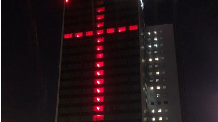 Riesiges Lichtkreuz   gegen das Hotel- und Gastrosterben