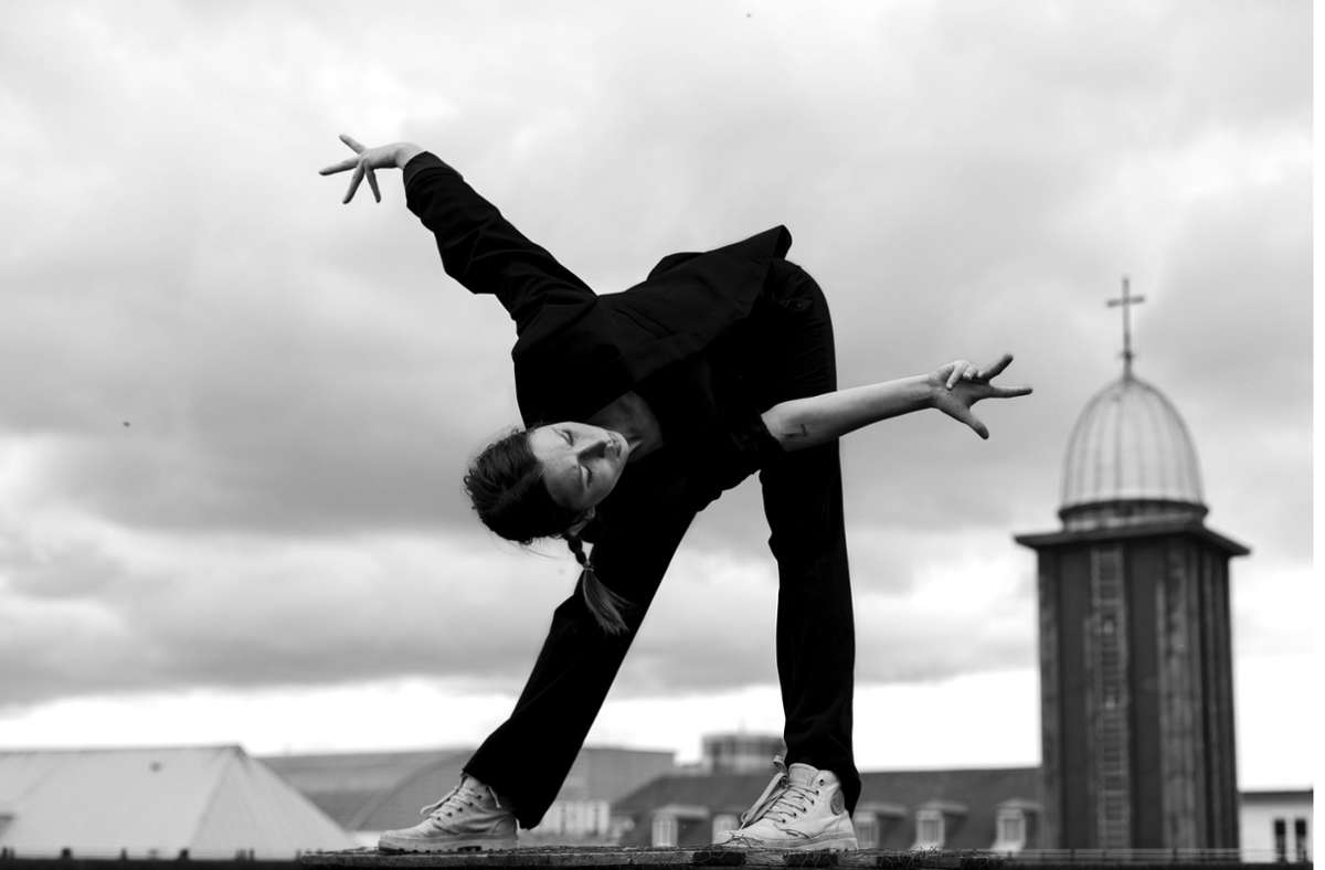 Tänzerin des Azimuth Arts and Dance Ensemble auf einem Hausdach im Zentrum von Stuttgart