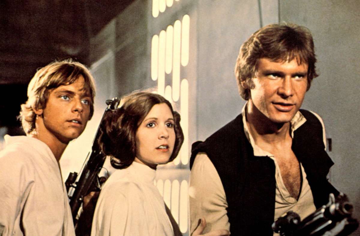 „Star Wars“ (George Lucas, 1977): Harrison Ford (rechts) als Han Solo mit Carrie Fisher und als Leia Organa und Mark Hamill als Luke Skywalker