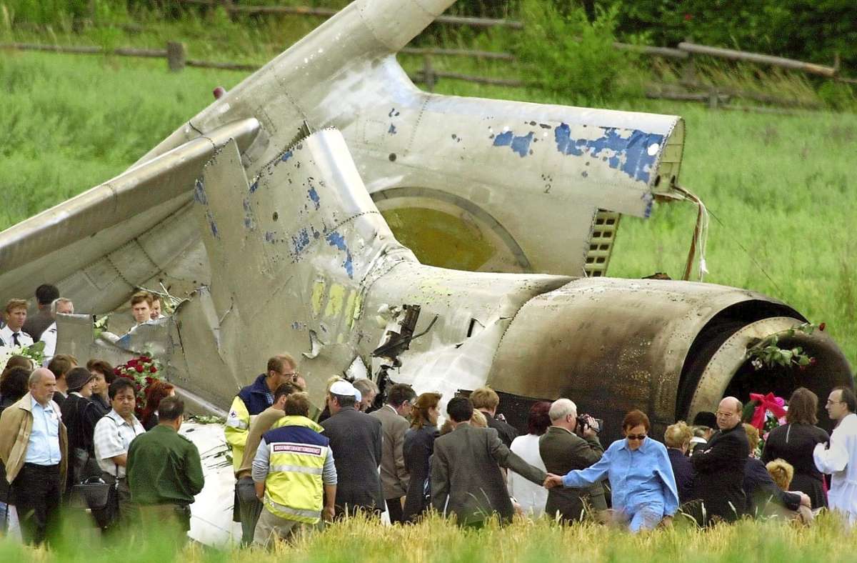 Angehörige der russischen Absturzopfer trauern mit Blumen und Kränzen am zerstörten Heck der Tupolew 154.