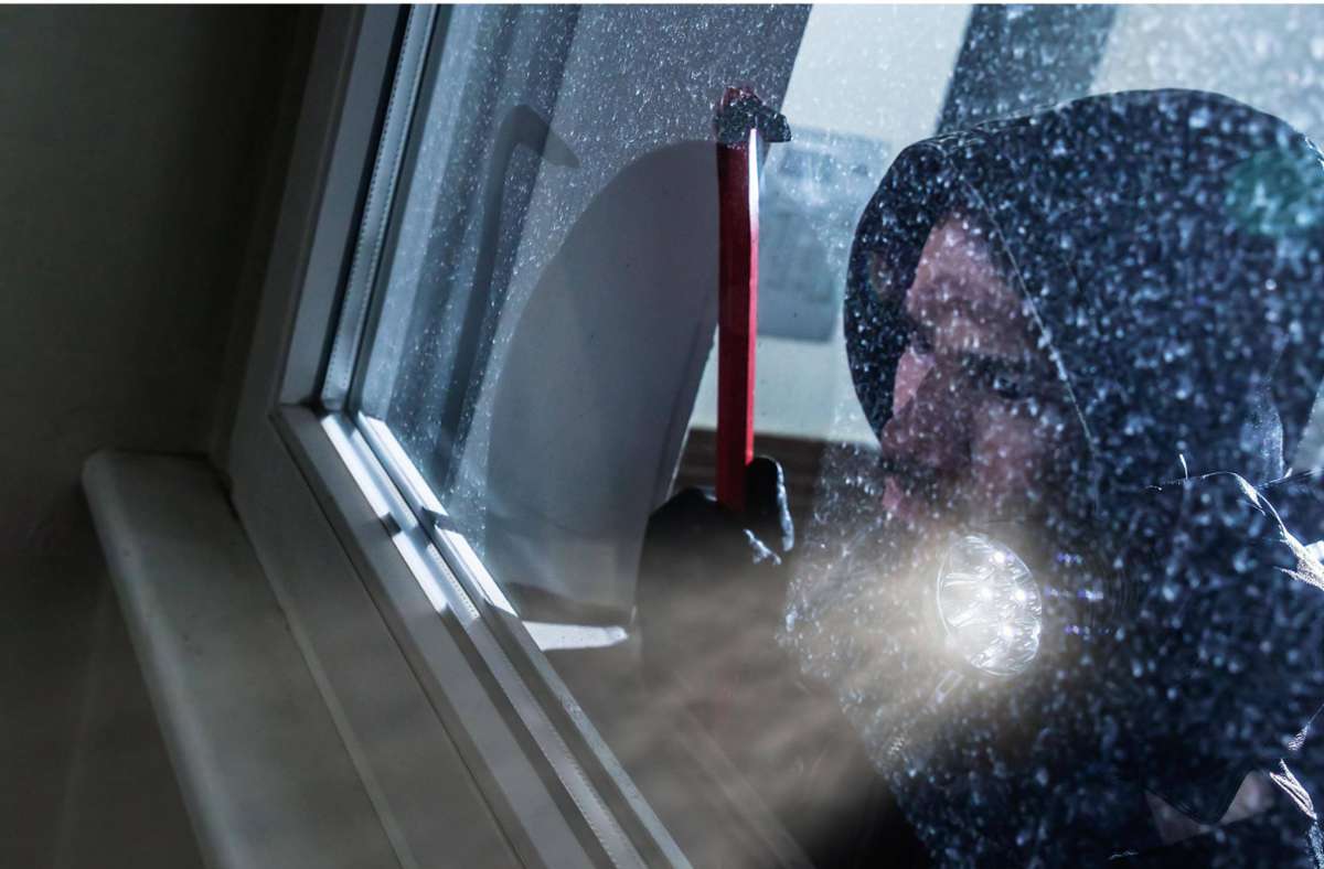 Ist hier die Luft rein? Ein Einbrecher hält Ausschau (Symbolbild). Foto: imago images/Andrey Popov