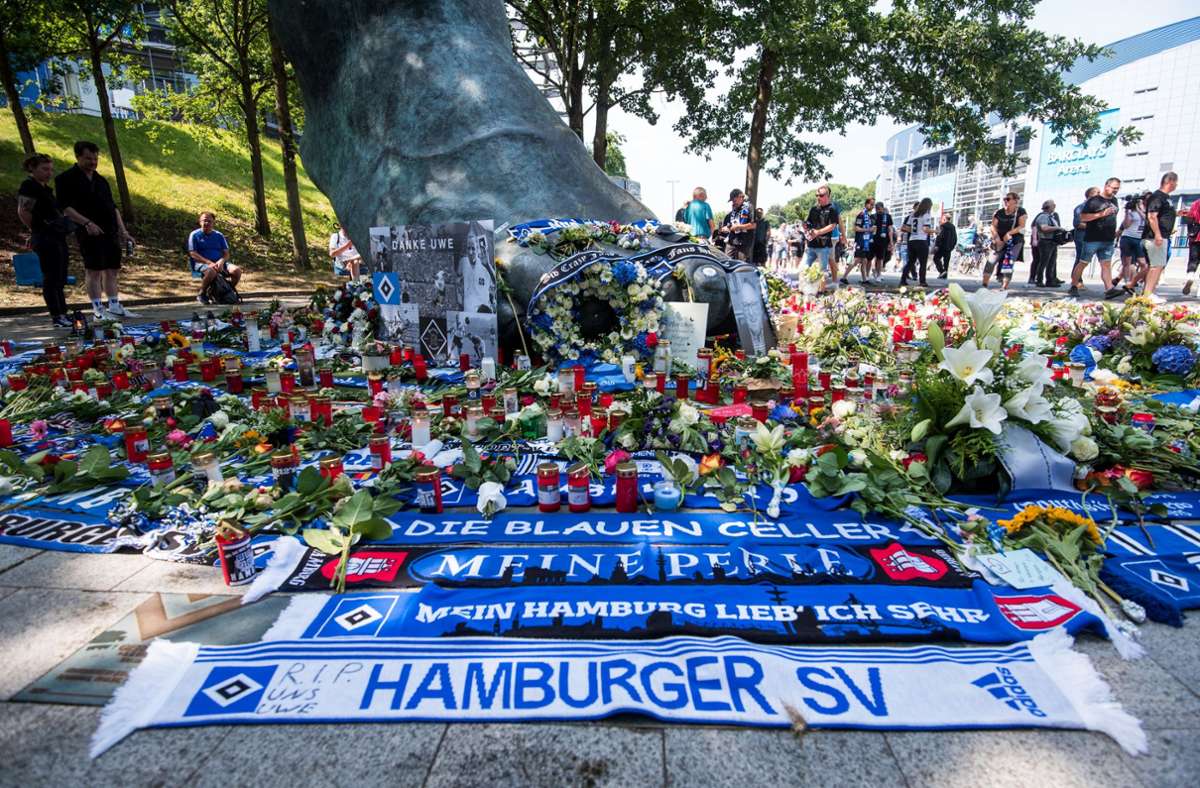 Zahlreiche Blumen, Kerzen und Schals vor dem Seeler-Bronzefuß am Hamburger Volksparkstadion. Foto: dpa/Daniel Bockwoldt