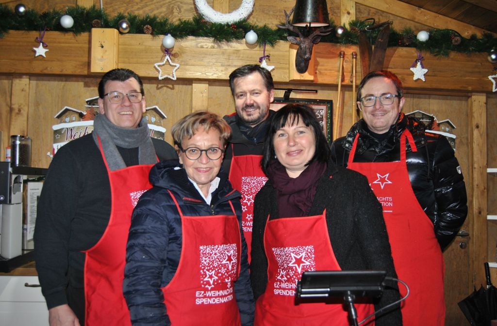 Promis schenken Glühwein für die EZ-Weihnachtsspendenaktion aus: Helfer und Hilfesuchende