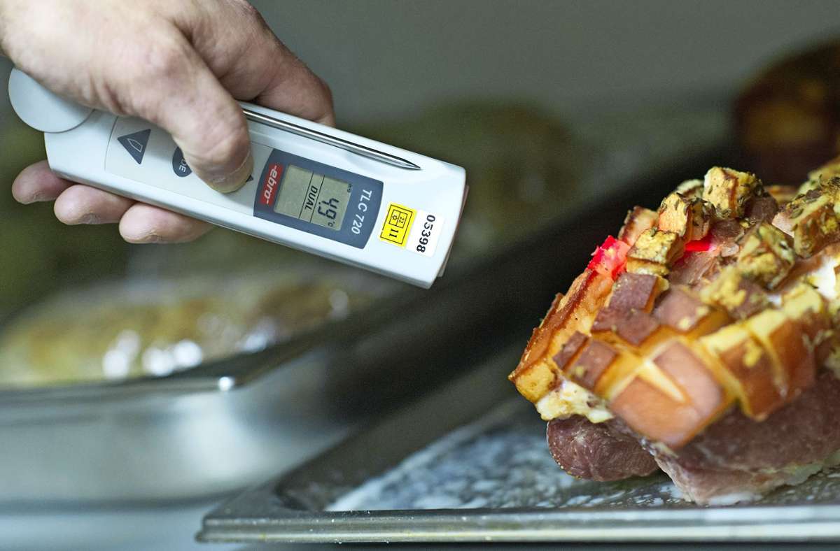 Ein Lebensmittelkontrolleur misst in einer Restaurantküche die Temperatur einer Speise. Foto: dpa/Uwe Anspach