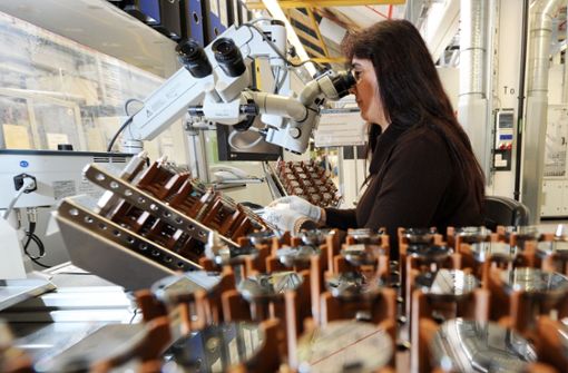 Eine Mitarbeiterin von Bosch prüft im Werk Feuerbach Dichtscheiben für Magnetventile, die  in der Dieseltechnologie eingesetzt werden. Foto: picture alliance/dpa/Bernd Weissbrod
