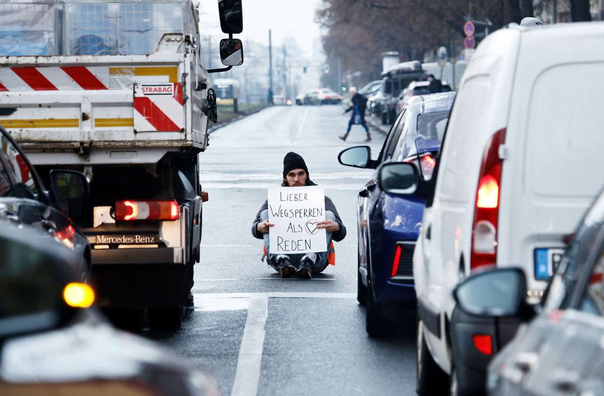 Ein Aktivist zeigt ein Schild mit der Aufschrift. „Lieber Wegsperren als Reden.“ Foto: dpa/Carsten Koall