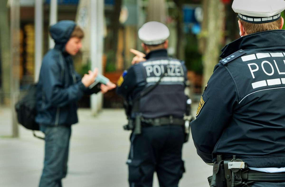 Die Polizei weist am Mittwoch Fußgänger auf die Maskenpflicht im Stuttgarter Cityring hin.