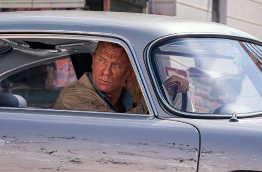 Daniel Craig sitzt ein letztes Mal als James Bond im Aston Martin. Foto: DANJAQ, LLC und MGM/Nicola Dove