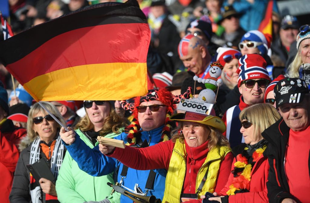 Biathlon-Fans feiern alle und alles – auf der Tribüne grenzt Deutschland direkt an Norwegen, und angefeuert werden die Sporttreibenden aus allen Nationen.