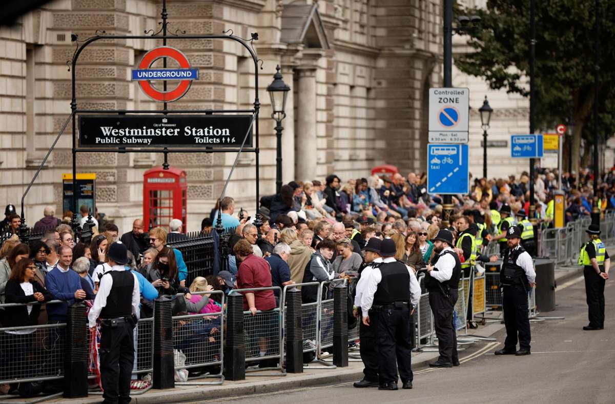Etliche Menschen warten auf die Prozession mit dem Sarg der Queen.