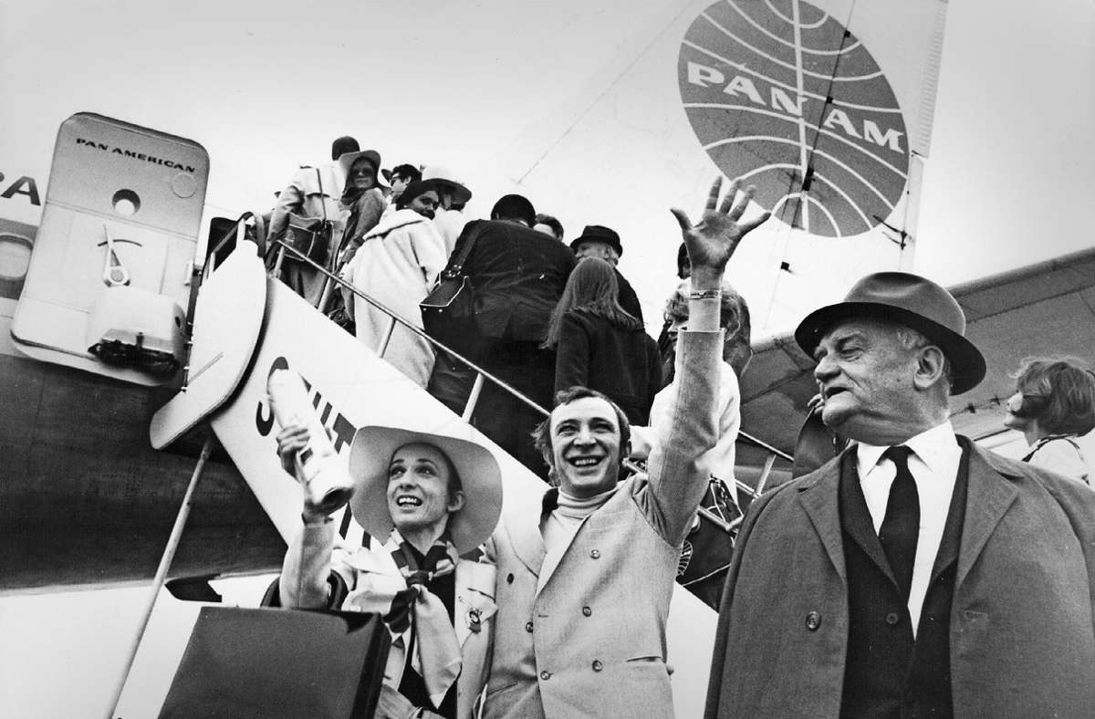 John Cranko (Mitte) mit seiner Primaballerina Marcia Haydée und dem Intendanten Walter Erich Schäfer winkt bei der Abreise zum Gastspiel 1969 nach New York am Stuttgarter Flughafen.