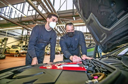Werkstattleiter Jochen Fischer (rechts) und der Auszubildende Lukas Krone beim gemeinsamen Blick unter die Motorhaube. Foto: Roberto Bulgrin