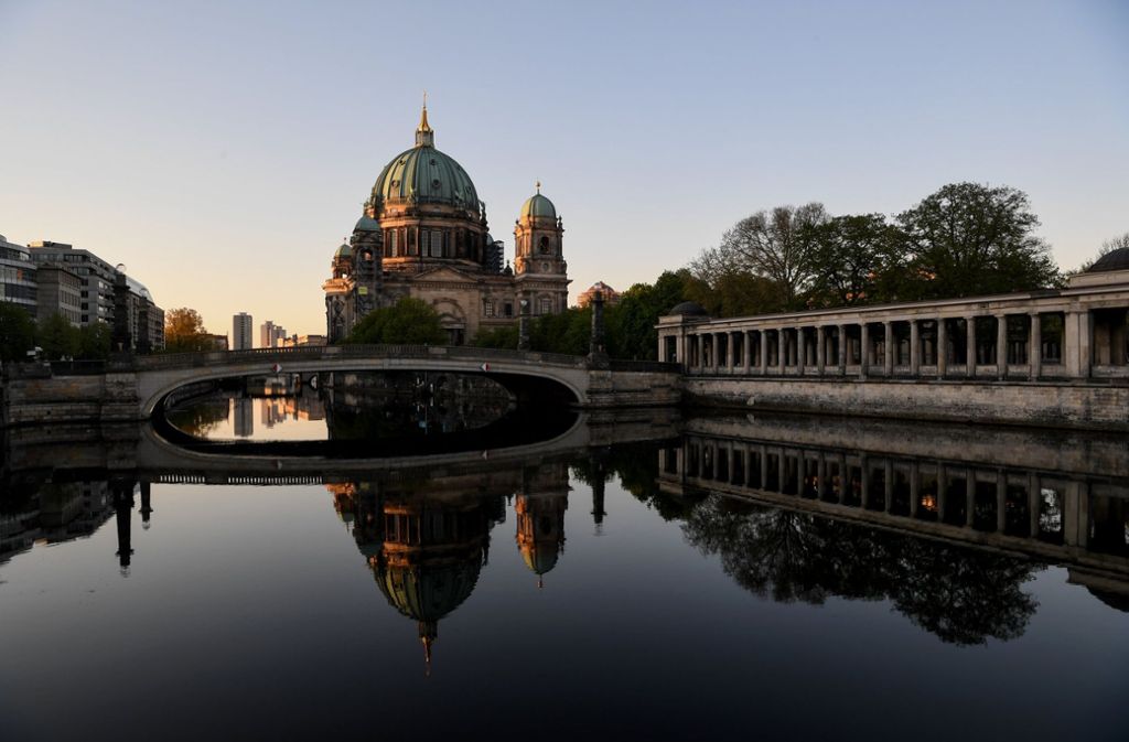Blick auf den Berliner Dom, der sich am frühen Morgen in der Spree spiegelt.