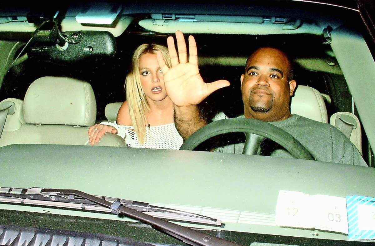 Britney Spears 2003: Die Geste ihres Fahrers, halb Begrüßung der Paparazzi, halb Abwehr, symbolisiert  das Problem des Starrummels.