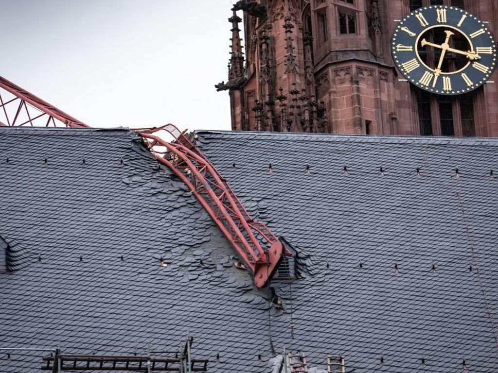 Auf den Frankfurter Dom gekracht: Der beschädigte Baukran wird vorerst gesichert und kann voraussichtlich erst Mitte der Woche entfernt werden. Foto: Frank Rumpenhorst/dpa