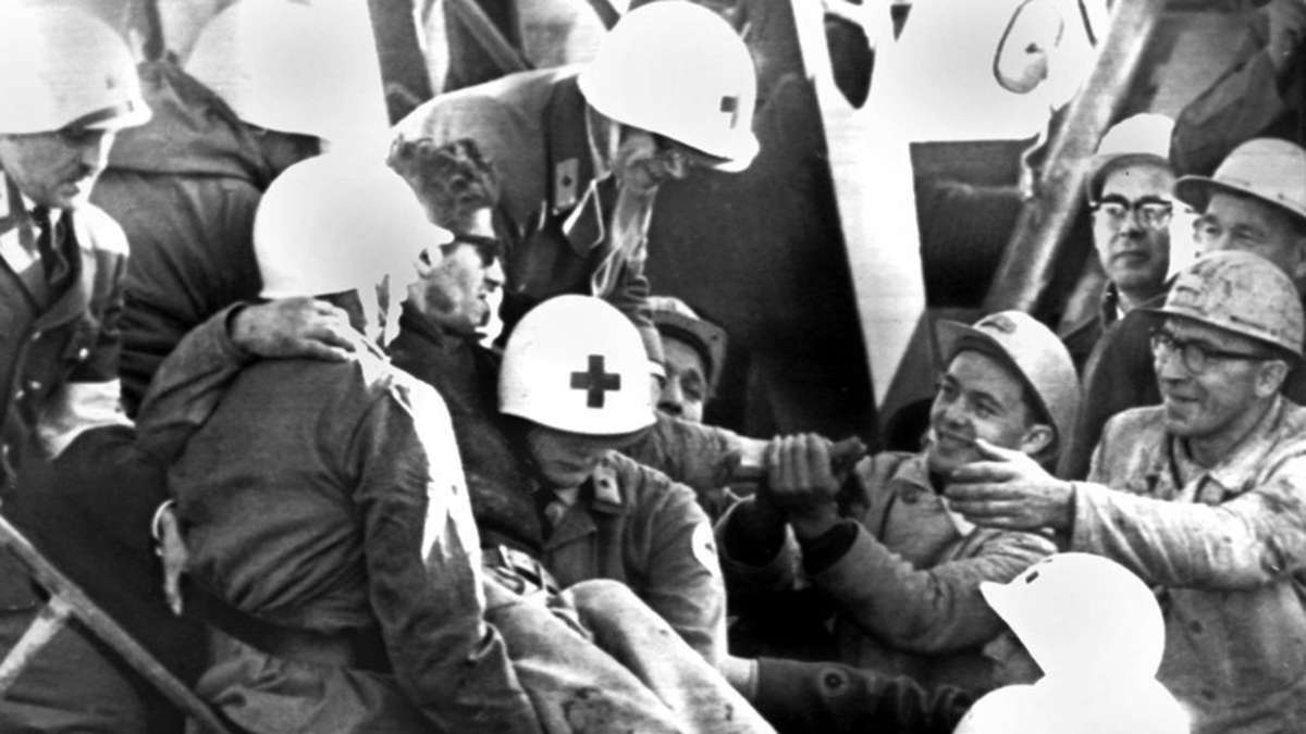 24. Oktober 1963: Helfer tragen während der dramatischsten Rettungsaktion in der Geschichte des deutschen Bergbaus an einer Bohrstelle im niedersächsischen Lengede einen der befreiten Bergleute ins Freie.