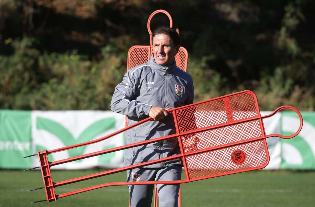Der VfB-Chefcoach geht zur nächsten Position, um den Trainingsdummy in den Rasen zu stecken.