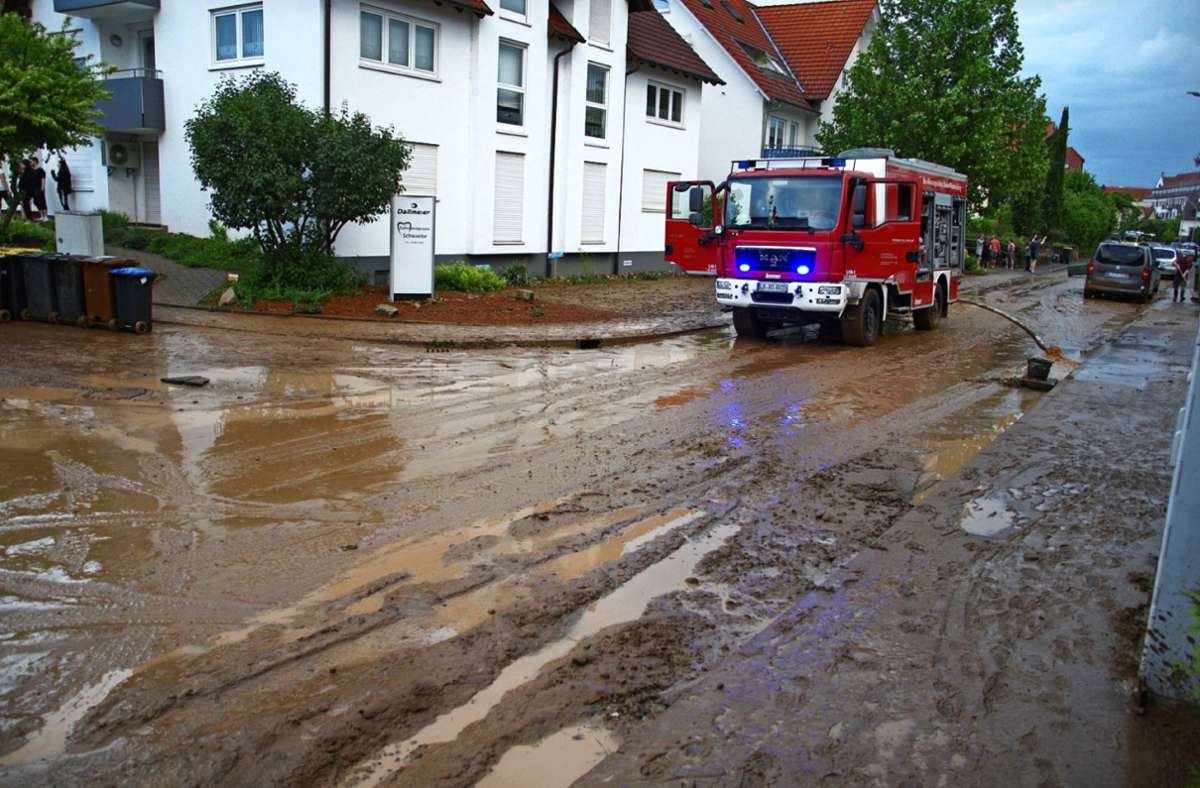 Schlamm und Wasser bahnen sich  in Oberstenfeld (großes Bild) sowie in Mundelsheim (rechts oben) und im Sauserhof ihren Weg durch die Straßen.