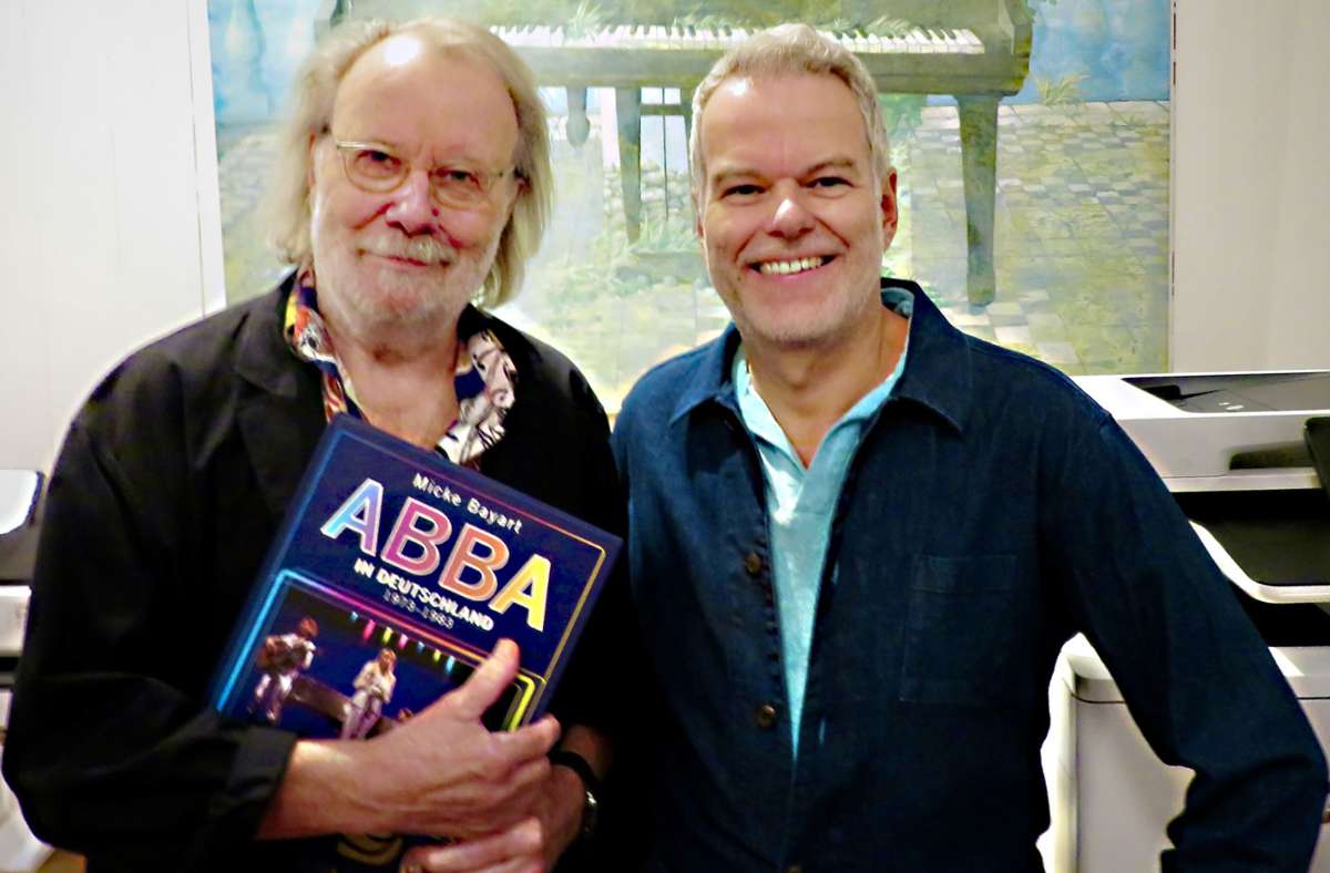 Micke Bayart (rechts) überreicht ein druckfrisches Exemplar seines Buches „Abba in Deutschland“ an seinen Lieblingsmusiker Benny Andersson.