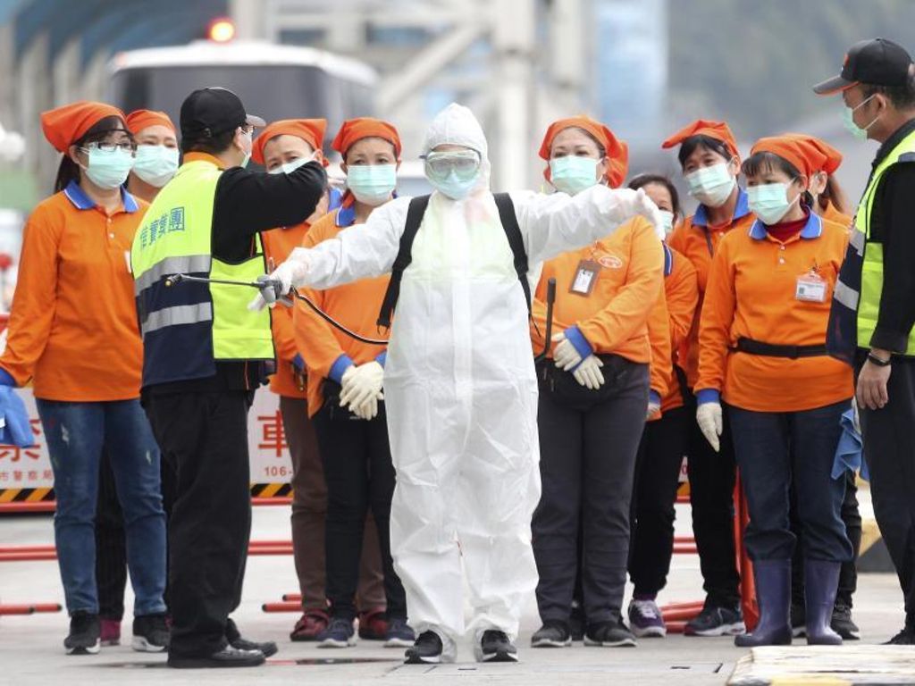Ein Mitarbeiter der Seuchenbekämpfung steht bereit, um im Hafen von Taiwans Hauptstadt Taipeh an Bord des Kreuzfahrtschiffes «SuperStar Aquarius» zu gehen. Foto: Chiang Ying-Ying/AP/dpa