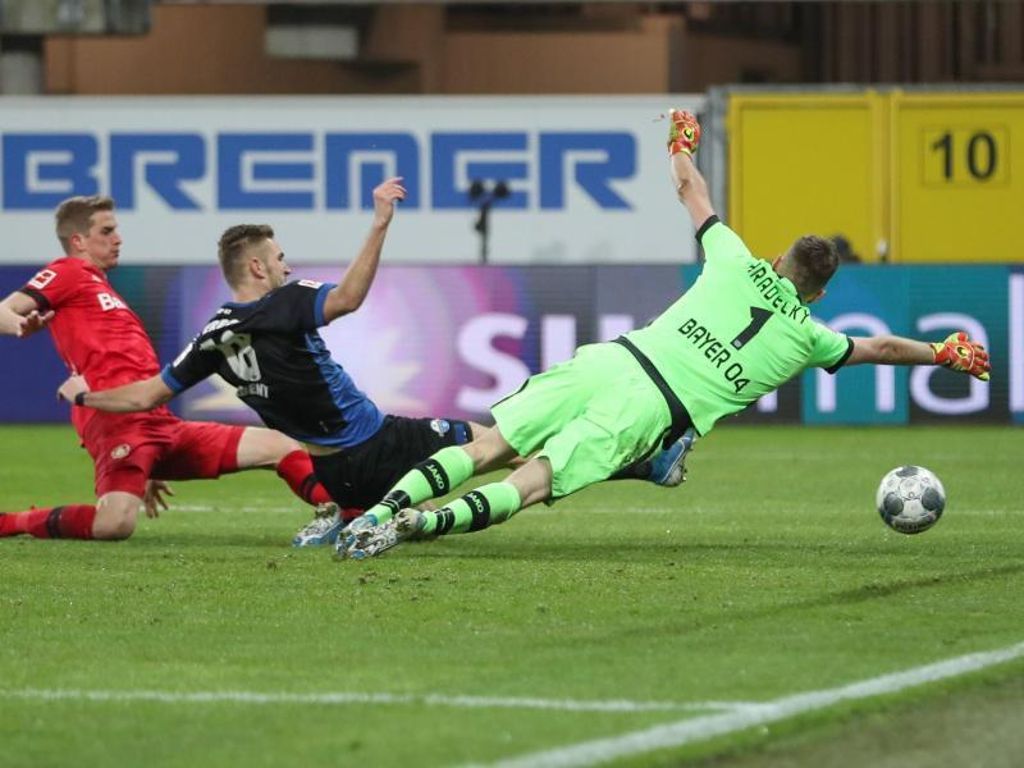 Paderborns Srbeny (M) erzielt den Treffer zum zwischenzeitlichen 1:3 - Bayers Schlussmann Hradecky streckt sich vergebens. Foto: Friso Gentsch/dpa