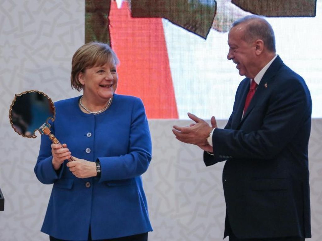 Präsident Erdogan überreicht der Kanzlerin einen Spiegel als Gastgeschenk. Foto: Ahmed Deeb/dpa