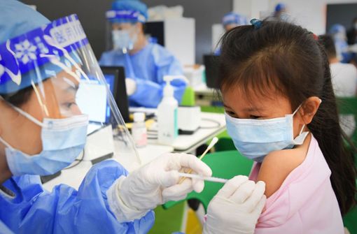 Ein medizinischer Mitarbeiter in China  injiziert einer Schülerin in einer Grundschule eine Dosis eines Corona-Impfstoffs. In Deutschland wird die Impfung ab Ende Dezember erwartet. Foto: dpa/Deng Hua