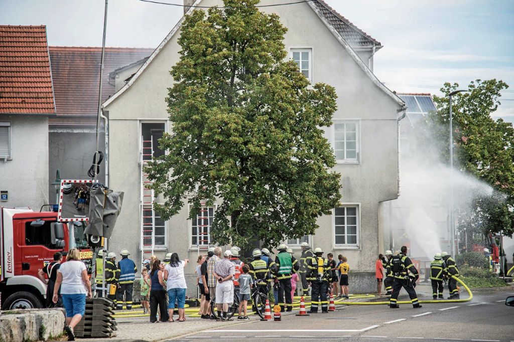 Zuschauer verfolgen die Hauptübung der Feuerwehr am Rathaus in Baltmannsweiler. Das Gebäude ist ein ideales Übungsobjekt, es weicht einem Neubau und wird deshalb abgerissen. Foto: SDMG